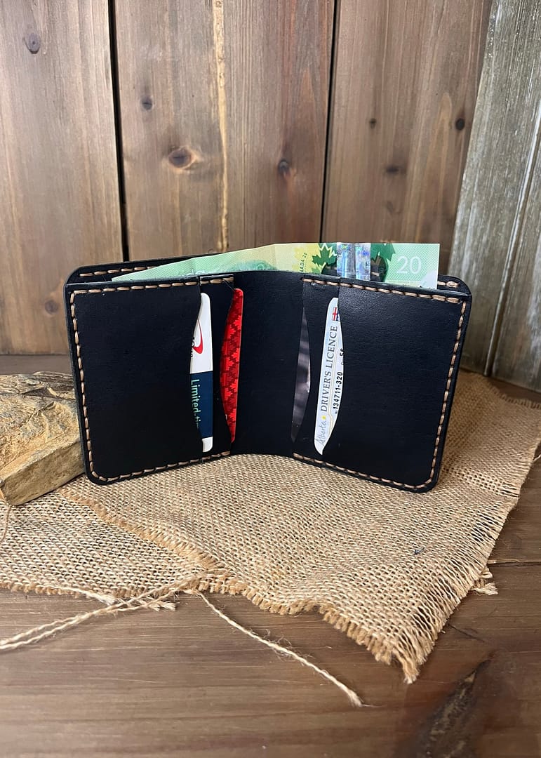 Open black handmade leather bifold wallet showing card slots and bill compartment